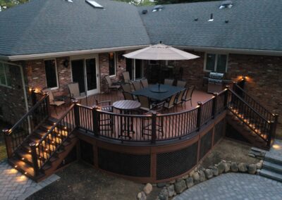 Custom curved deck in Mahwah using composite decking and railings with lattice skirting and lighting