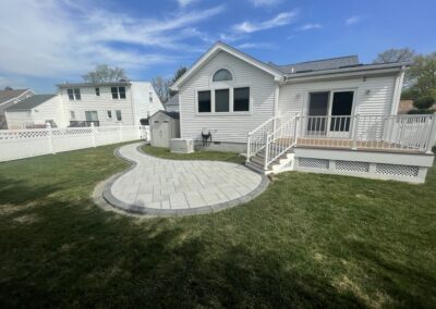 Deck with composite decking, aluminum railings, and lattice skirting with a patio and walkway